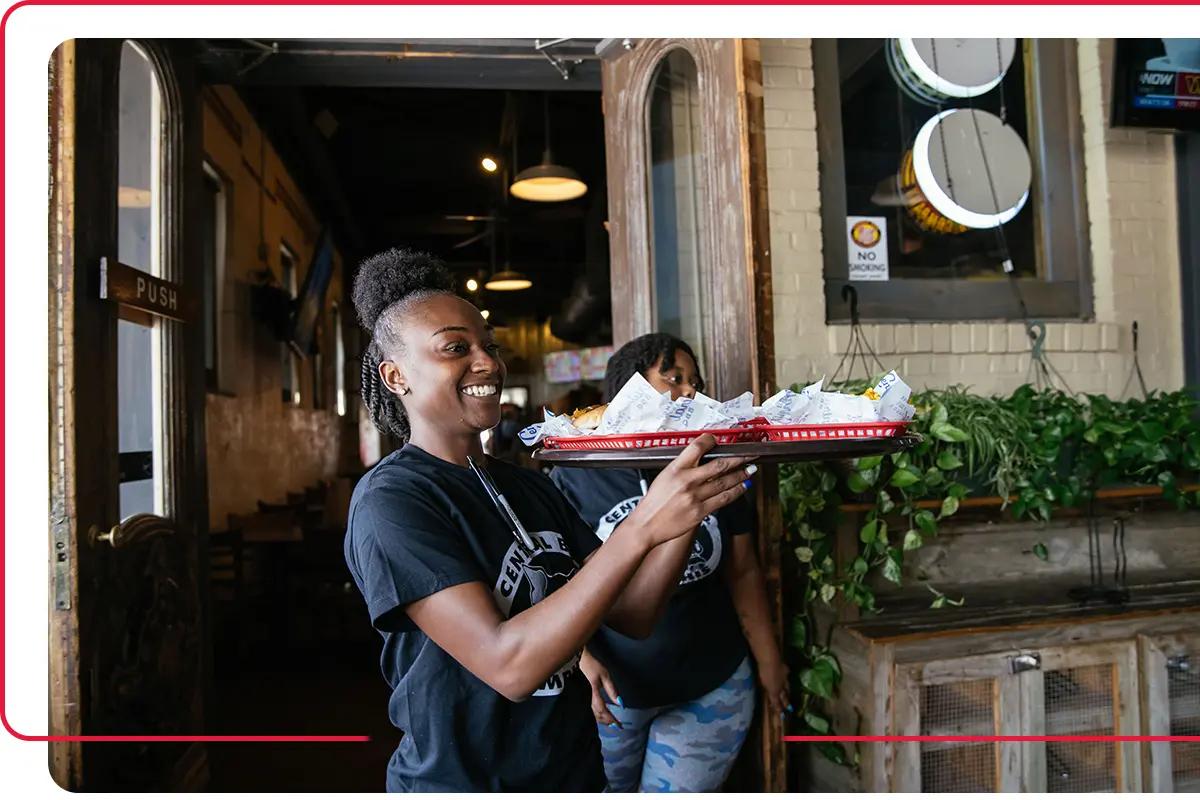 Waitress carrying a tray of food in a local Tennessee restaurant