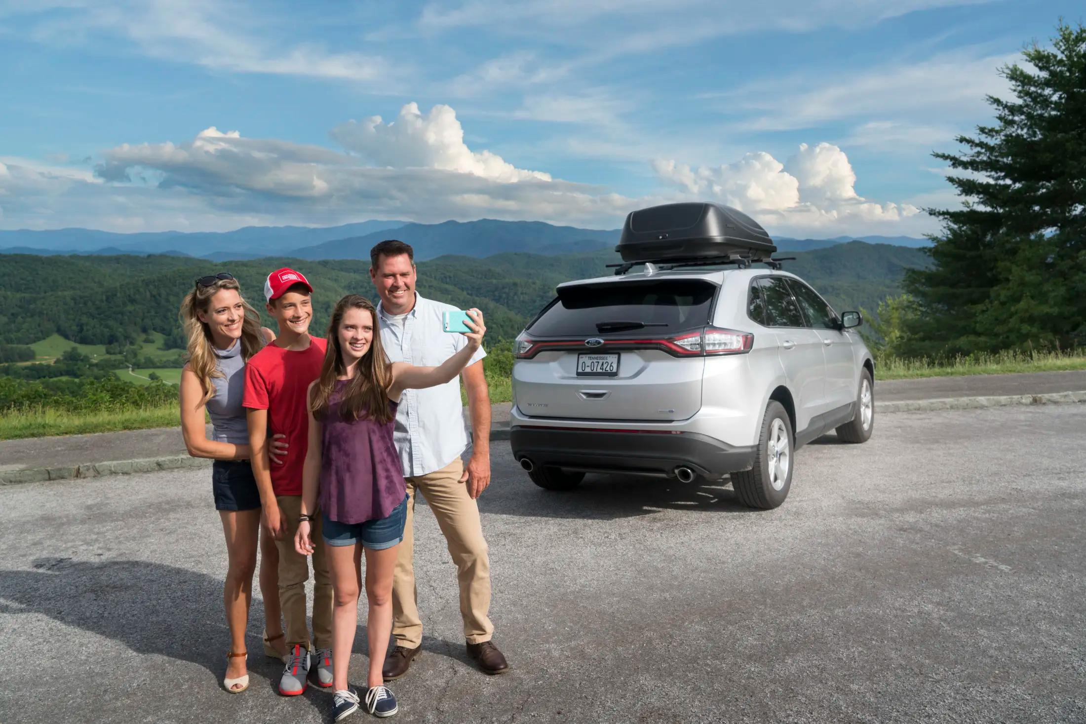 Tennessee family taking selfie next to car while traveling in mountains