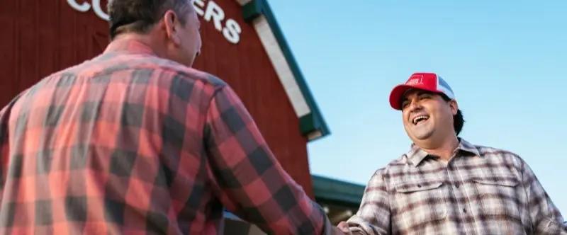 Farm Bureau Insurance of Tennessee agent shaking hands with farmer outside of local co-op